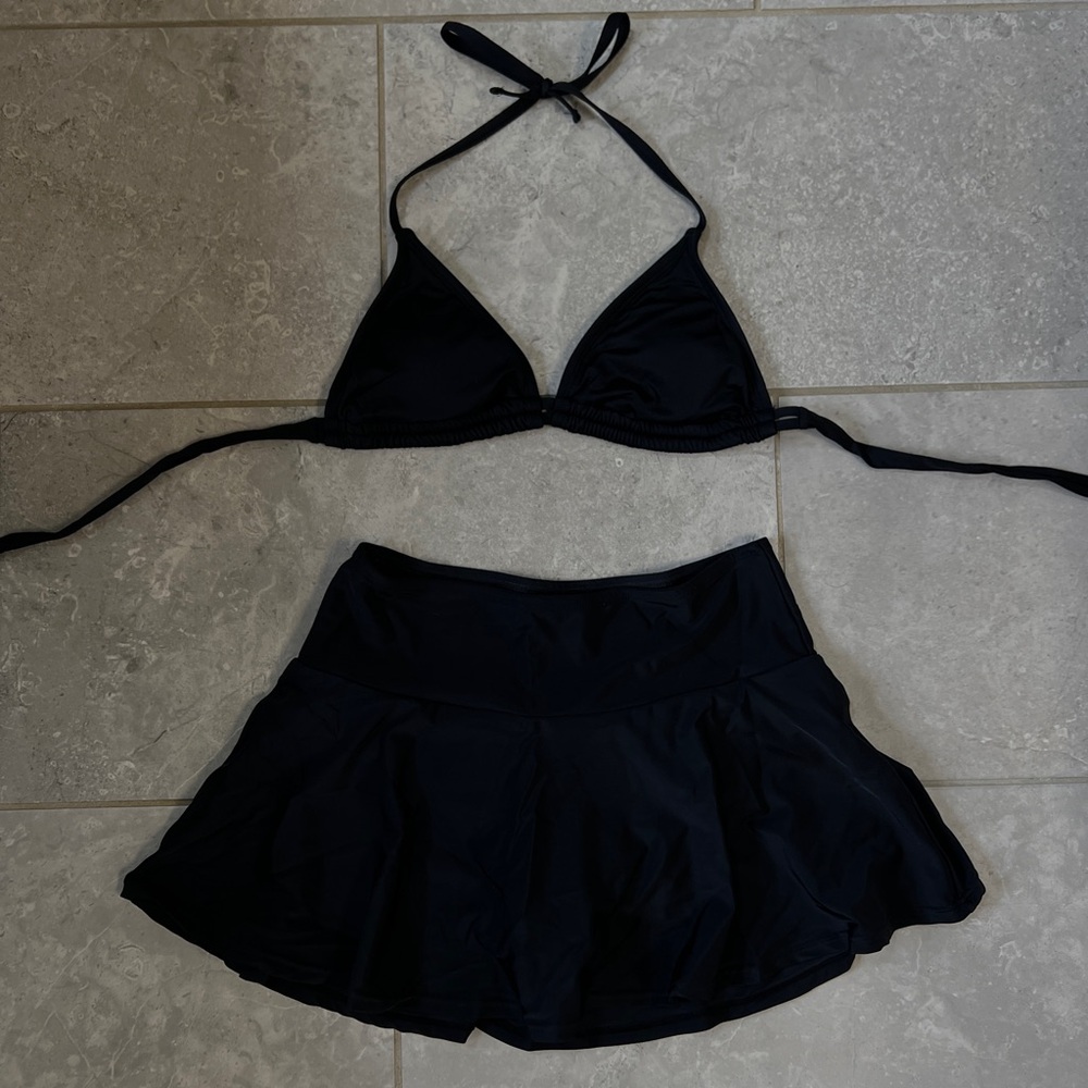 Adult medium black swimsuit bikini top and skirt with attached bottoms.